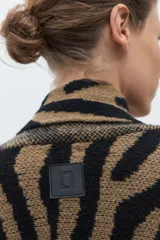 Ruana de punto jacquard con estampado animal print de cebra en colores negro y tostado, de diseño abierto y corte holgado.