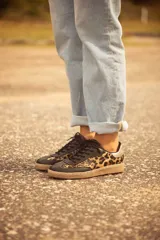 Zapatillas bajas de cuero con estampado animal print y detalles en cuero celeste.