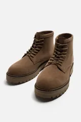 Bota de hombre color beige de cuero serraje con cordones, puntera redonda y suela track.