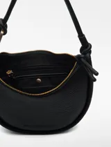 Bolso de hombro negro con textura granulada. Tiene un compartimento con cierre de cremallera, asa tubular con pieza metálica y logo grabado.