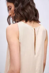 Vestido largo color crema, de corte recto y sin mangas, con detalle de bordado calado en cuello y sisas.