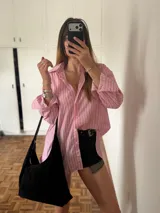 Bolso negro de gamuza con cierre dorado y compartimentos internos, uno de ellos con cierre.