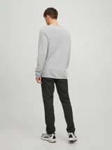 Sweater de punto gris claro jaspeado, de manga larga y cuello redondo.