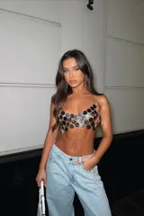 Top tipo corpiño compuesto por círculos metálicos plateados unidos entre sí, con tiras de cadena finas para atar al cuello y espalda.