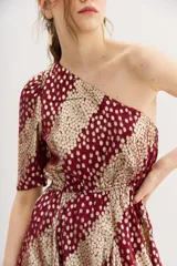 Vestido corto de un hombro, con manga larga con frunces en el hombro y ajuste con elástico en la cintura. Confeccionado en viscosa jacquard con lurex, con estampado de manchas color dorado sobre fondo borgoña.