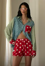 Camisa oversize de tela liviana, combinada en verde, celeste y rojo con estampado de lunares blancos y bolsillo frontal rojo.