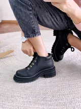 Borcegos negros de cuero con cordones y suela track.