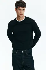Remera negra de punto de algodón liviano, de corte estándar, con cuello redondo ribeteado y bajo recto.