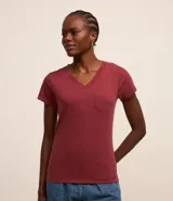 Blusa blanca de algodón con cuello en V, manga corta y bolsillo frontal.