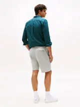 Pantalón corto deportivo gris de felpa, con cintura elástica ajustable con cordón, bolsillos laterales y logo de Tommy Hilfiger bordado en el ruedo.