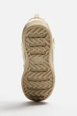Zapatilla deportiva color beige, estilo skate. Capellada fabricada en combinación de piezas y materiales. Lengüeta acolchada. Detalle de cordones de cuerda. Tirador trasero para facilitar el calce. Suela con volumen y diseño irregular.
