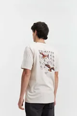 Remera color crema de manga corta con estampado de águilas y texto distorsionado en la espalda. Corte regular.