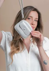 Monedero de dama color negro, con textura granulada, correa de mano y cierre principal. Incluye un bolsillo frontal con solapa y botón, y un portallaves en el interior.