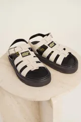 Sandalias de cuero sintético color lila con plataforma negra y tiras anchas cruzadas.