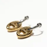 Aros plateados tipo argolla con dije dorado en forma de eslabón.