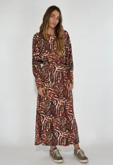 Vestido con estampado abstracto en tonos marrones, de corte largo y mangas largas.