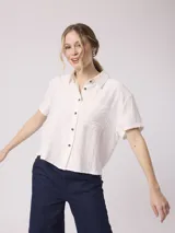 Camisa blanca de manga corta con cuello clásico y bolsillo en el pecho. Confeccionada en lino y viscosa.