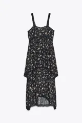 Vestido negro con estampado floral, escote recto y tirantes finos. Detalle de aplicación de hilo metalizado, lentejuelas y puntilla combinadas a tono. Bajo asimétrico.