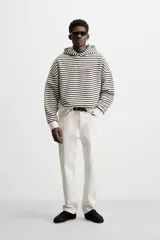Sudadera con capucha a rayas horizontales blancas y negras, corte boxy fit, mangas largas y texto bordado en color rosa en el pecho.