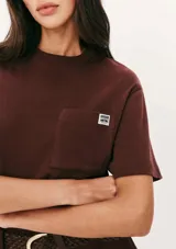 Camiseta manga corta color marrón con bolsillo en el pecho y parche con logo.