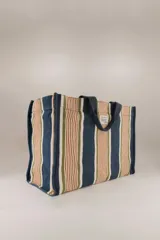 Bolso tote de algodón con rayas verticales en azul, verde, marrón y blanco. Tiene doble asa corta color azul marino y un bolsillo interior.