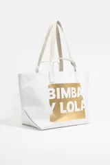 Bolso shopper blanco con logo Bimba y Lola estampado en dorado. Tiene doble asa de mano y bolsillo interior con cremallera.