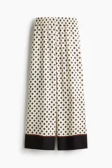 Pantalón de corte holgado con cintura elástica de tiro alto, bolsillos laterales discretos y piernas amplias.