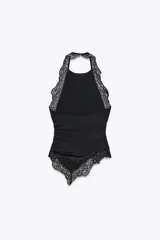 Top negro con textura, cuello halter y detalle de encaje.