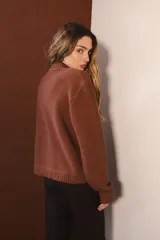 Bomber negra con rayas verticales blancas y flores rojas bordadas. Tiene cierre frontal y bolsillos.