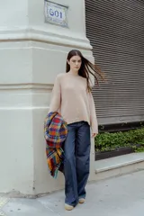 Sweater beige de tejido bouclé, con cuello redondo y mangas largas.