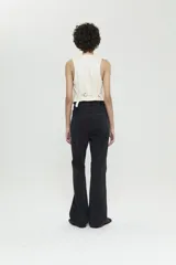 Jean bootcut de tiro medio, pierna ajustada y bota acampanada. Confeccionado en tela bull color negro con lavado rockero y tachas aplicadas en los bolsillos traseros.