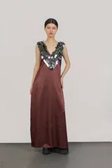 Vestido largo de seda color bordó, con escote en V y apliques de lentejuelas iridiscentes en el cuello y los hombros.
