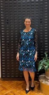 Vestido negro de manga larga, confeccionado en guipur bordado con flores azules y blancas.