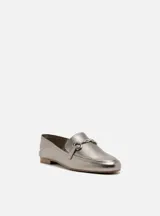 Mocasín plateado de cuero con detalle de hebilla metálica.