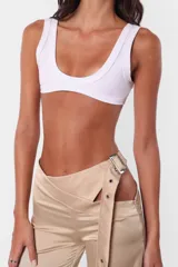 Microtop musculosa sin mangas, confeccionado en microfibra pesada con terminaciones en collareta ancha en escote, contorno inferior y sisas. La parte más angosta de la prenda responde al delantero. Se puede usar de ambos lados, reversible.