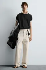Pantalón negro de corte recto, con bolsillos frontales tipo parche y bolsillos traseros de ojal.