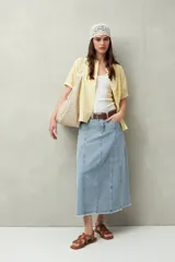 Camisa blanca de manga corta abullonada, cuello mao y botones forrados.