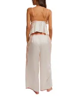 Conjunto de pijama de satén color crema, compuesto por un top sin mangas con escote en V y detalles de encaje rosado, y un pantalón palazzo con cintura elastizada y detalles de encaje rosado en los laterales.