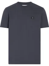 Remera azul de algodón de corte regular, cuello redondo y mangas cortas. Presenta una pequeña insignia con el monograma de Calvin Klein en el pecho.