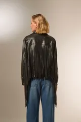 Chaqueta de cuero sintético negra con flecos en la espalda y mangas, cuello camisero, cierre frontal con cremallera y bolsillos laterales.