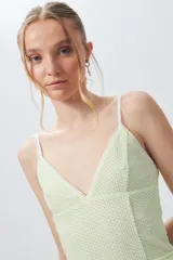 Top ajustado color menta con estampado, escote en V y tirantes finos.