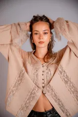 Camisa color beige con encaje en la parte delantera y en las mangas, de corte holgado.