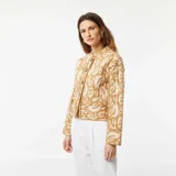 Chaqueta corta acolchada color beige con estampado abstracto en blanco, cuello redondo y cierre frontal con botones.