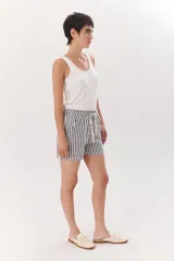 Short de tela color blanco con rayas verticales negras, cintura elastizada con cordón ajustable.