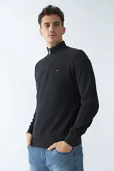 Buzo negro de algodón con cuello alto y medio cierre. Tiene logo bordado en el pecho y puños en las mangas.