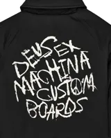 Campera negra tipo coach con cuello clásico, cierre con botones a presión, puños elásticos y cordón ajustable en el ruedo. Estampado en el pecho con el logo de la marca Deus Ex Machina.