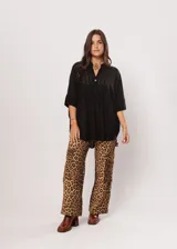 Camisa negra con calados, escote en V, abotonada y manga 3/4.