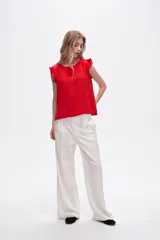 Blusa roja de poliéster con cuello a la base y volados en los hombros.