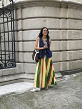 Chaleco de jean sin mangas con cuello en V y cierre frontal con botones metálicos. Tiene dos bolsillos de parche en el pecho y corte recto.