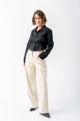 Camisa corta negra de algodón y elastano, con cuello clásico, mangas largas con puños elásticos, cierre frontal con botones y cintura elastizada.